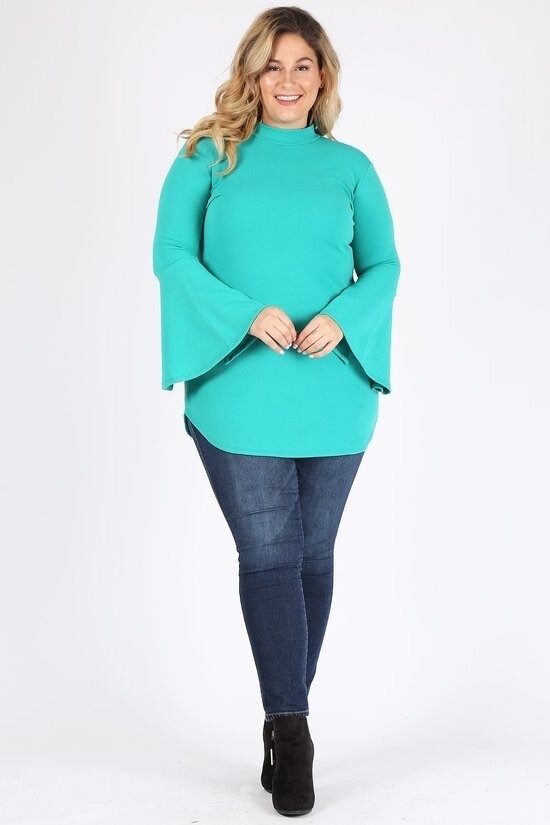 Solid long sleeve top with mock neckline, bell sleeves, and pockets.