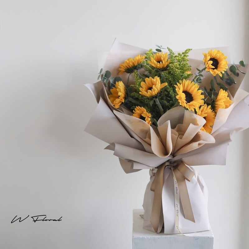 Fresh sunflower bouquet with modern beige wrapping