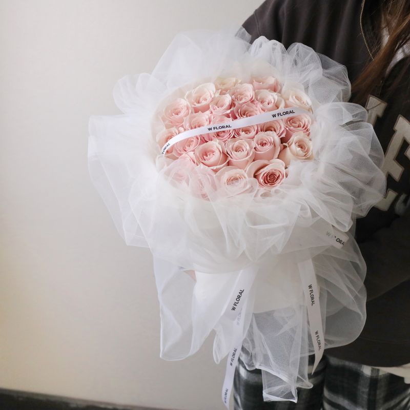 Soft pink rose bouquet wrapped in delicate white chiffon for romantic gifting