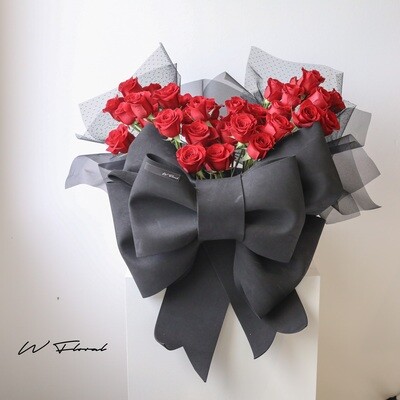 Red rose hug bucket with oversized black bow by W Floral Studio