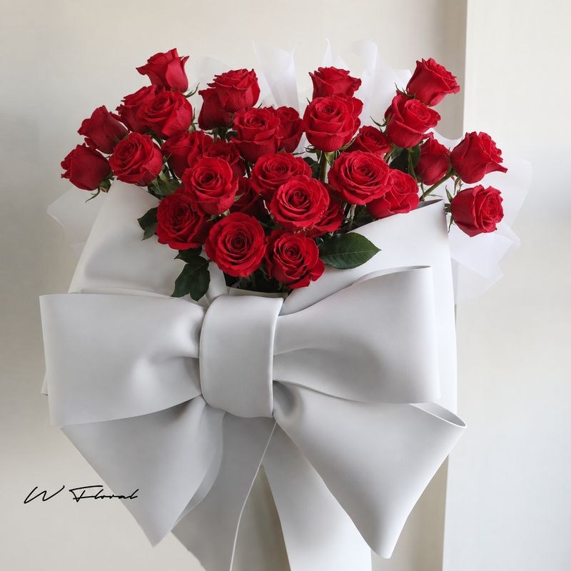 Red rose hug bucket with oversized white bow by W Floral Studio