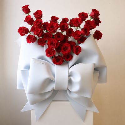 Red rose hug bucket with oversized white bow by W Floral Studio
