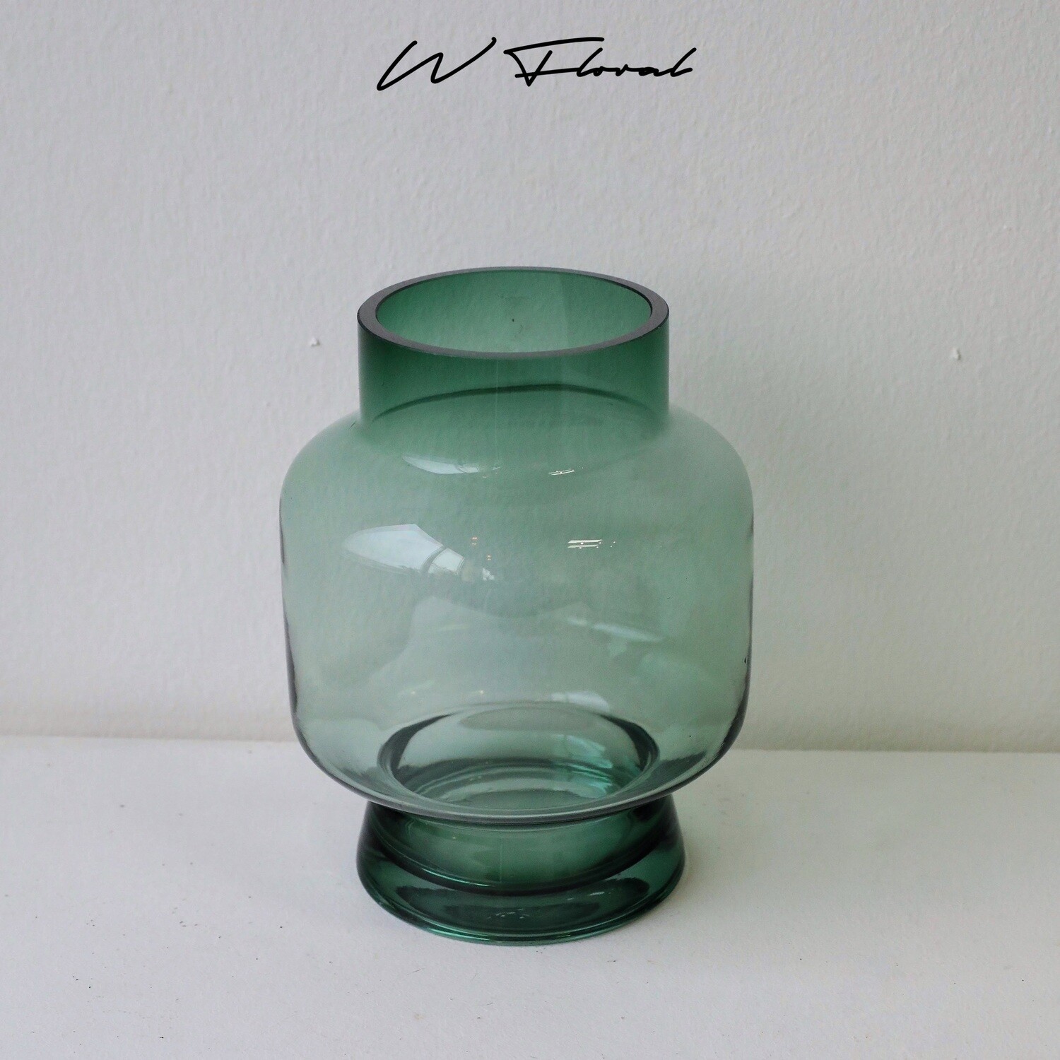 Emerald green glass vase with modern wide-waist silhouette
