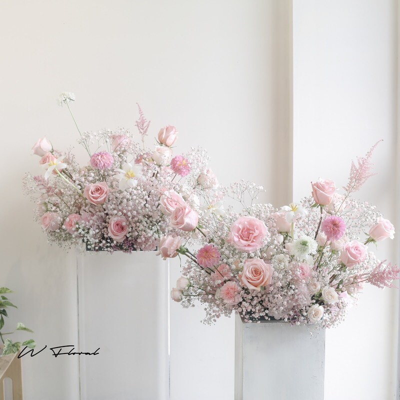 Blush pink wedding ceremony arrangement with roses and baby’s breath