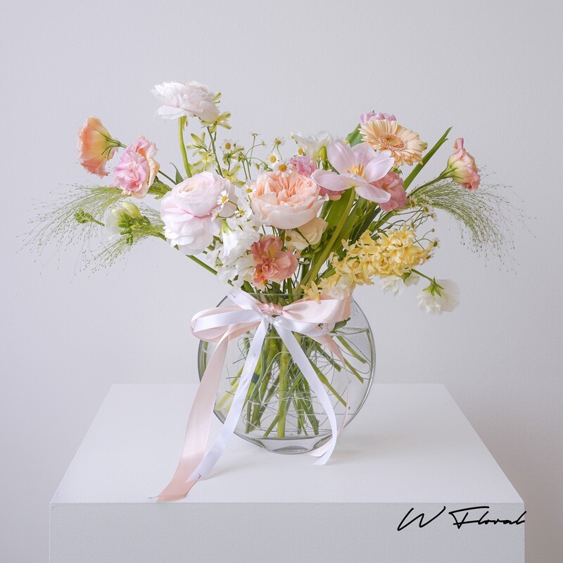 Pastel seasonal flower arrangement in round glass vase Toronto