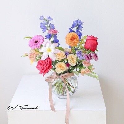 Bright colourful vase flower arrangement with seasonal blooms