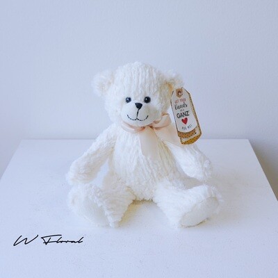 Soft teddy bear toy paired with a fresh flower bouquet