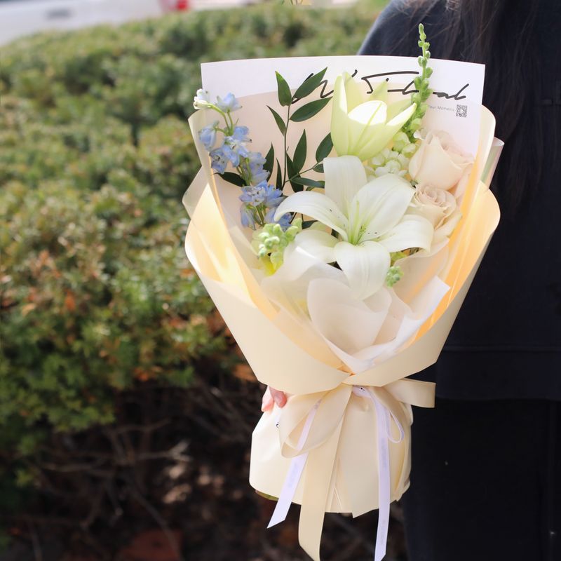 White lily bouquet with roses and blue seasonal flowers