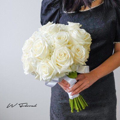 Bride holding white rose and hydrangea round wedding bouquet