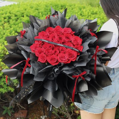 Elegant red rose bouquet with flowing ribbon details and round shape