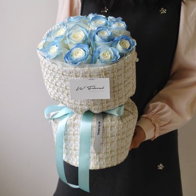 Elegant spray-painted blue rose bouquet with textured tweed fabric