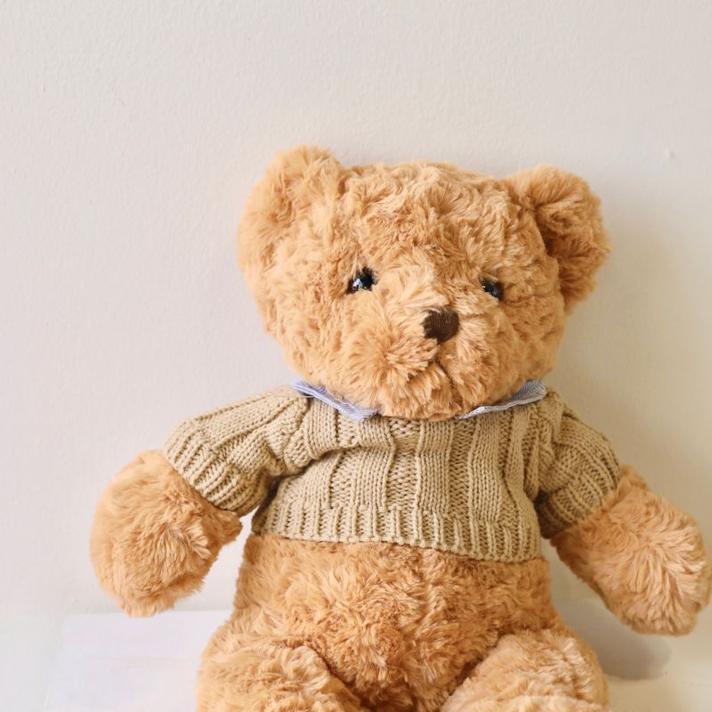 Cuddly large teddy bear presented alongside a flower bouquet