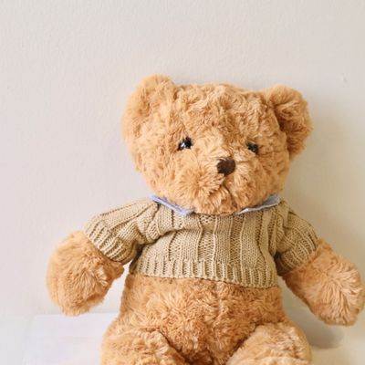 Cuddly large teddy bear presented alongside a flower bouquet