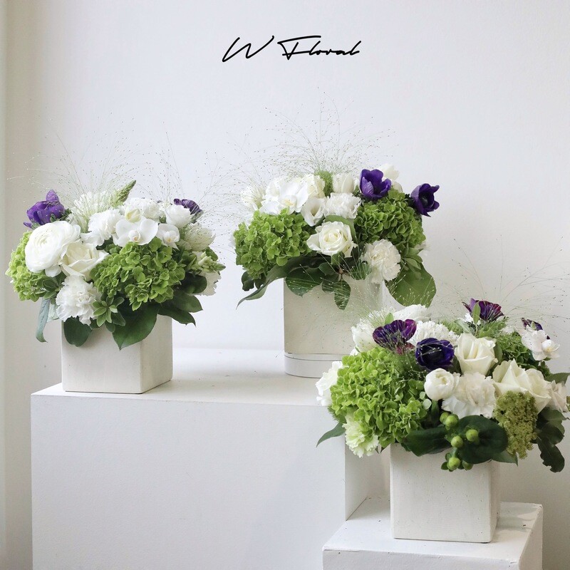 Contemporary floral arrangements in white square pots for event styling