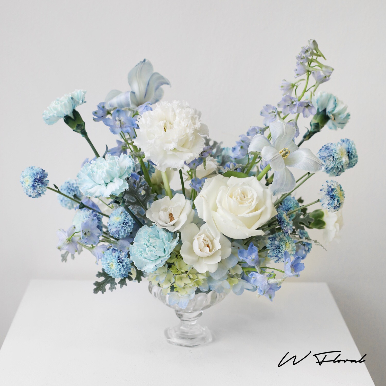 Elegant floral centrepiece in clear glass pedestal bowl