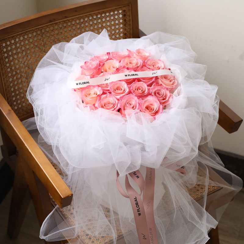 Soft pink Rhoslyn rose bouquet with elegant white chiffon wrapping