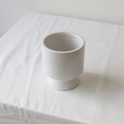White pedestal vase with minimalist cylindrical shape and raised base