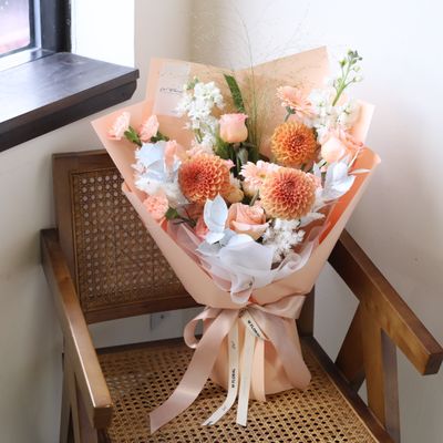 Warm peach floral bouquet in a natural hand-tied style