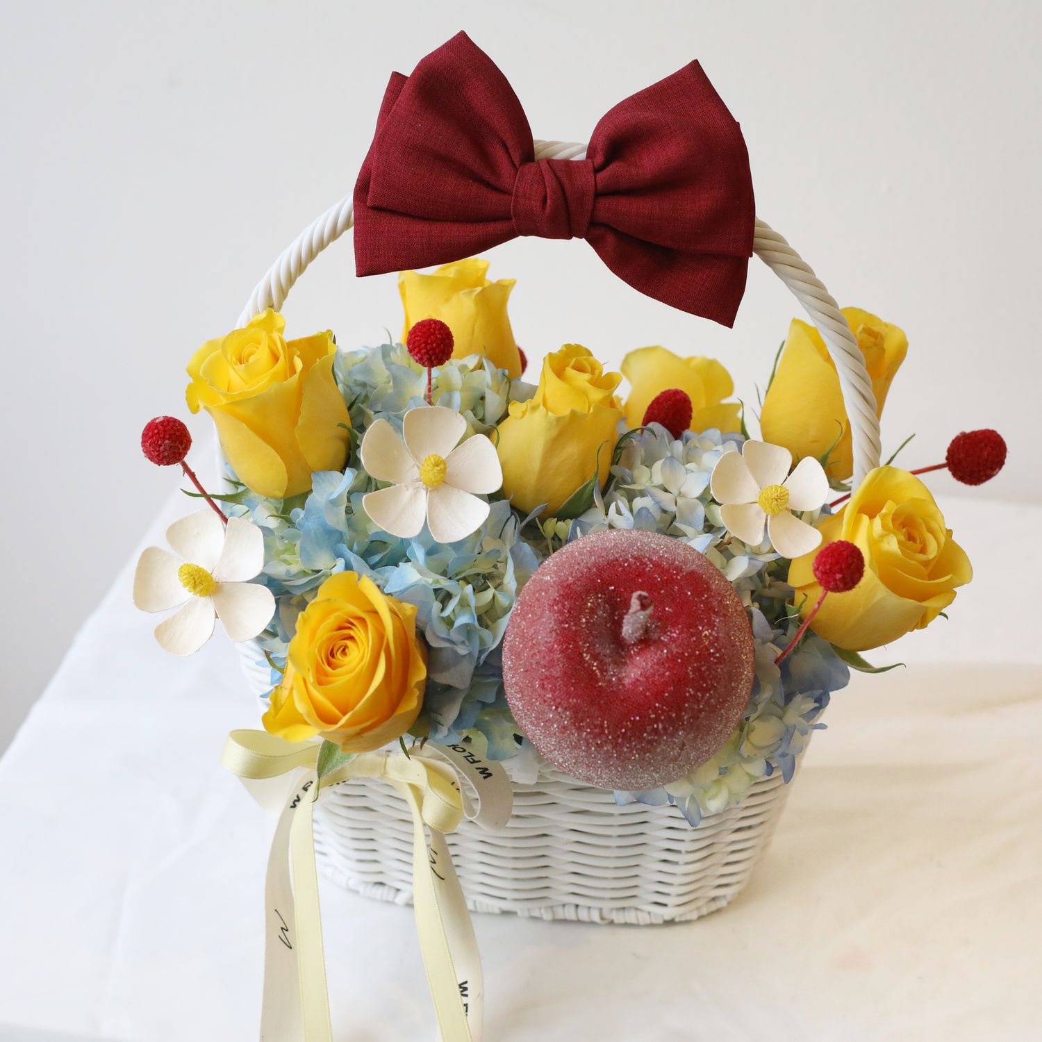 Snow White flower basket with yellow roses, blue hydrangea and white flowers