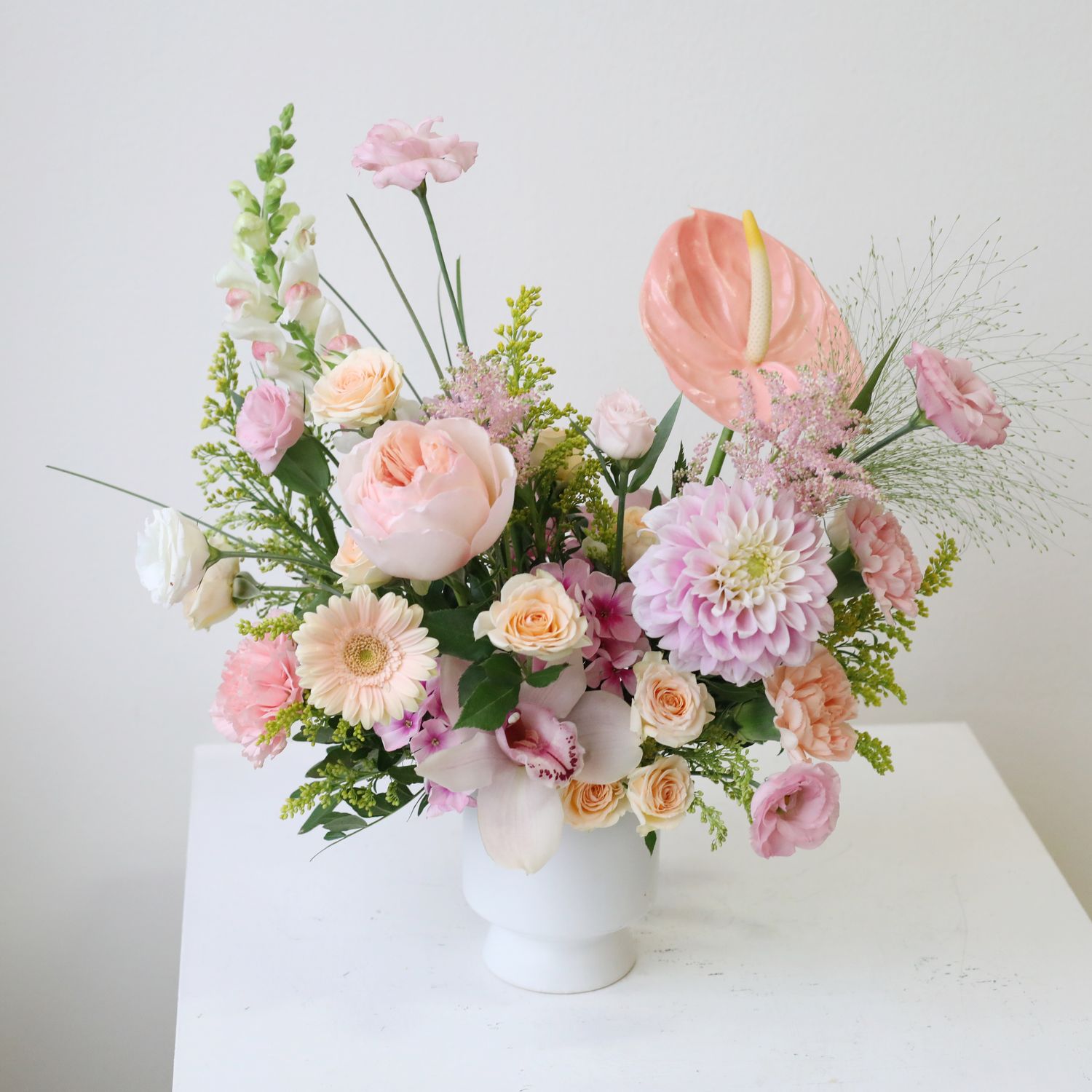 White footed wedding flower centrepiece with pastel seasonal blooms