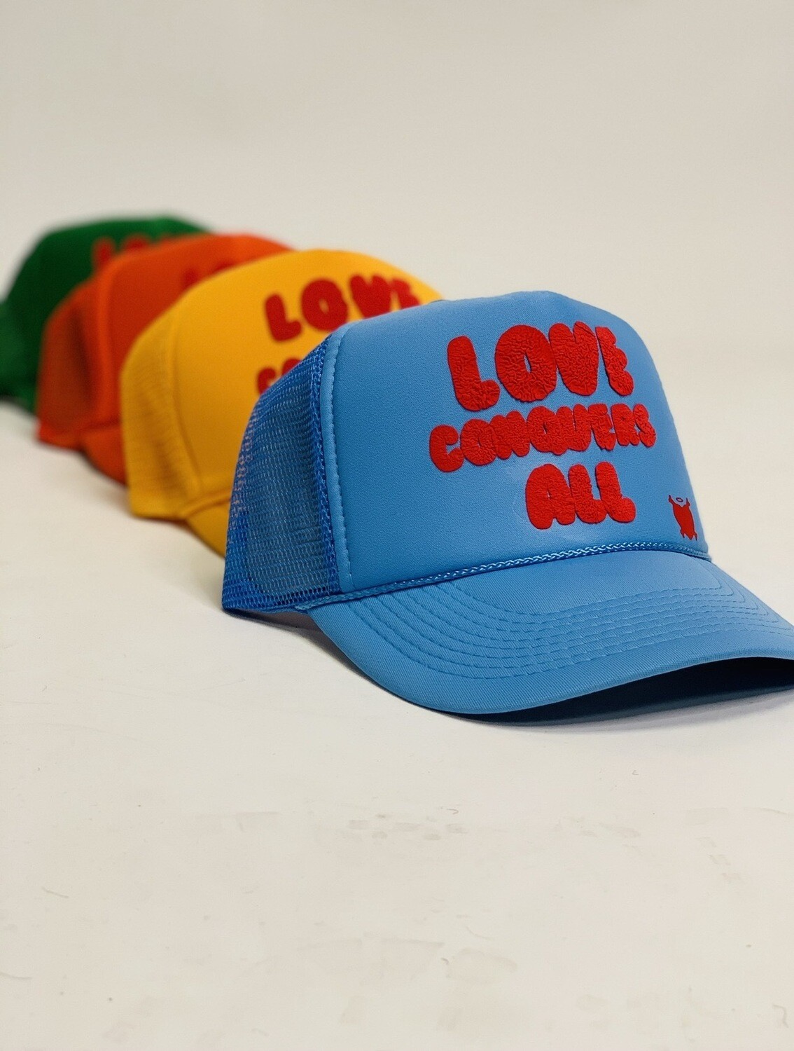 “Love Conquers All” Trucker Hats