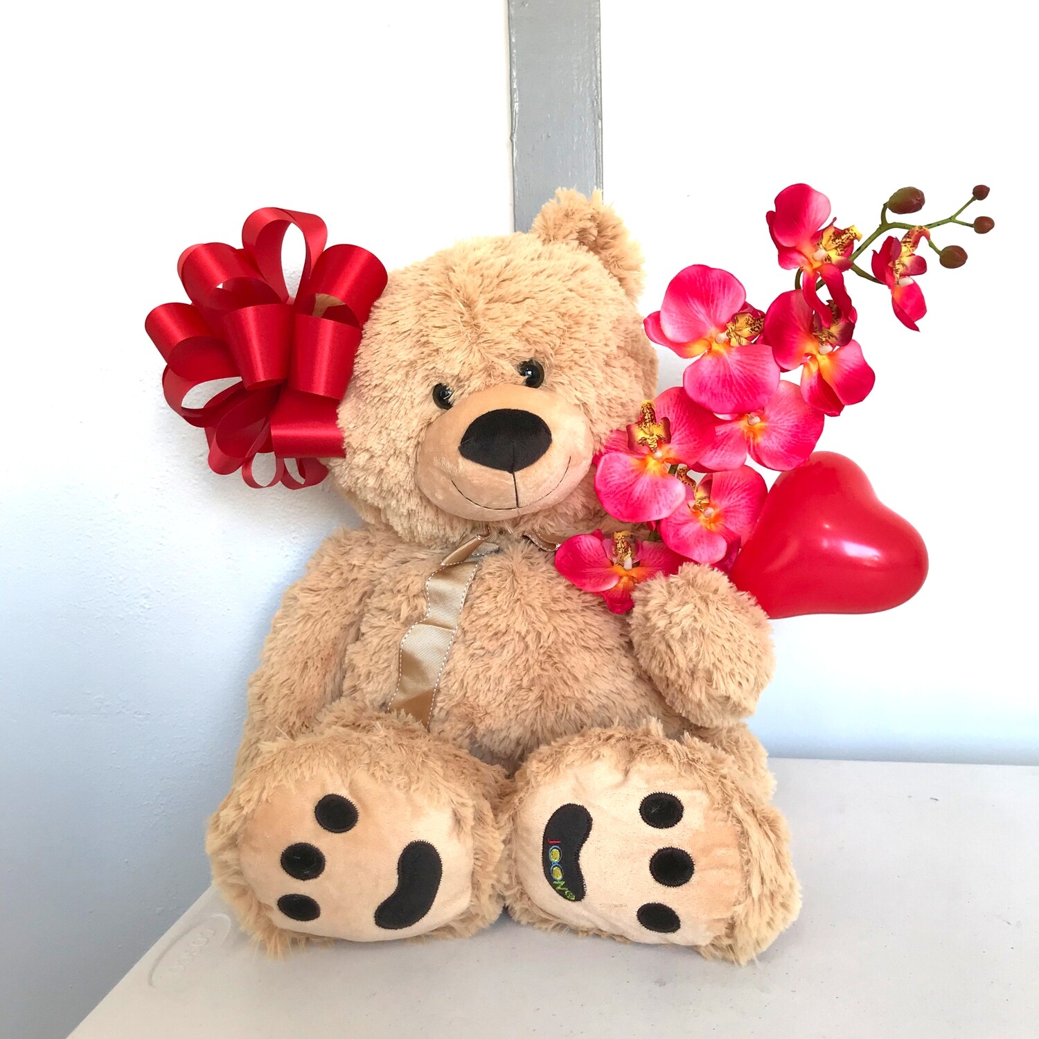 Big teddy bear with bow and orchid