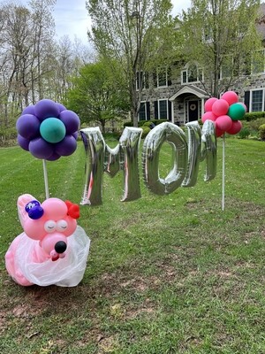 big MOM banner on 2 flower topiaries with indoor poodle balloon (outdoors)