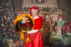 Mrs. Claus with singing turkey puppet