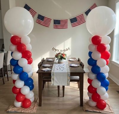 8-foot balloon column with white topper and 2 foil footballs on each