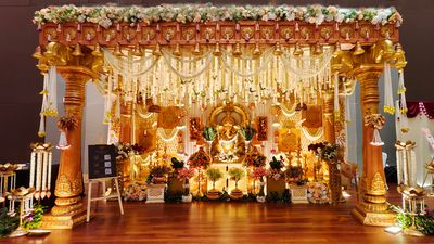 Chettiar house pillar inspired wedding mandap with golden carved pillars and jasmine garlands