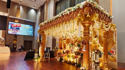 Chettiar house pillar inspired wedding mandap with golden carved pillars and jasmine garlands