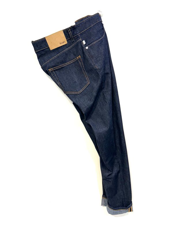 Jeans in denim elasticizzato non lavato effetto “ rinse “. Col. Blu notte