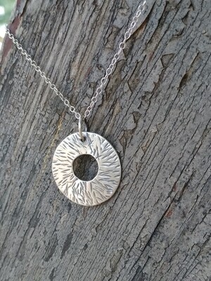 Hammered 925 Sterling silver disc pendant on a chain.