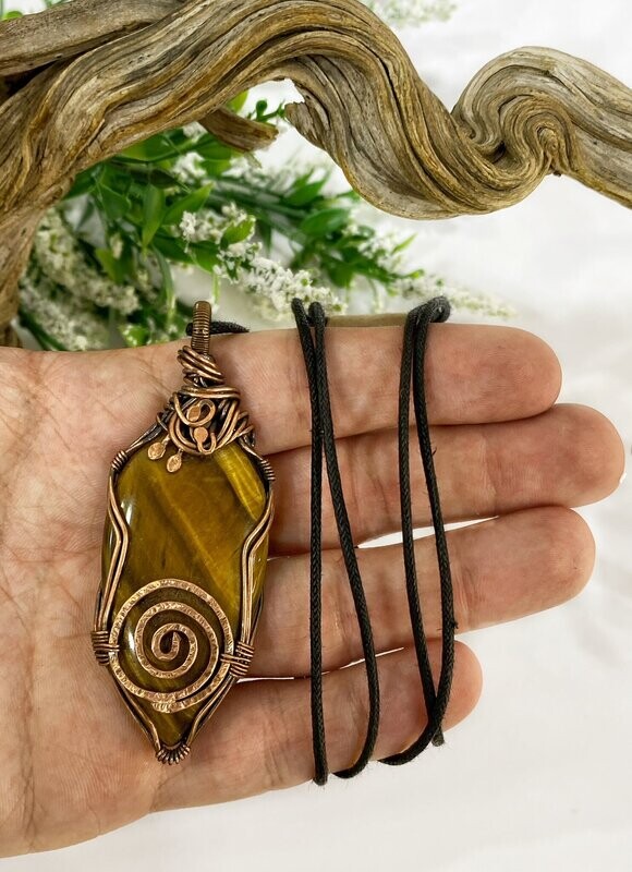 Tiger eye wire wrapped copper pendant with a spiral at the base.