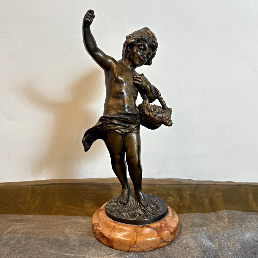 Escultura en bronce de niña con cesta de frutas