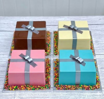 Medium Christmas Gift Smash Cakes in milk, white, pink and blue chocolate, presented together as festive chocolate presents f