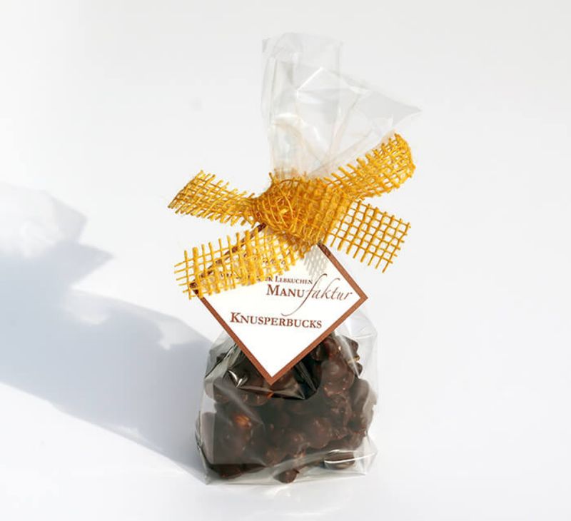 Knusperbucks Zartbitter, fein-geröstete Haselnüsse und leckere Cranberrys umgeben von edler Zartbitterkuvertüre 130g Knusperbucks Zartbitter, fein-geröstete Haselnüsse und leckere Cranberrys umgeben von edler Zartbitterkuvertüre 130g