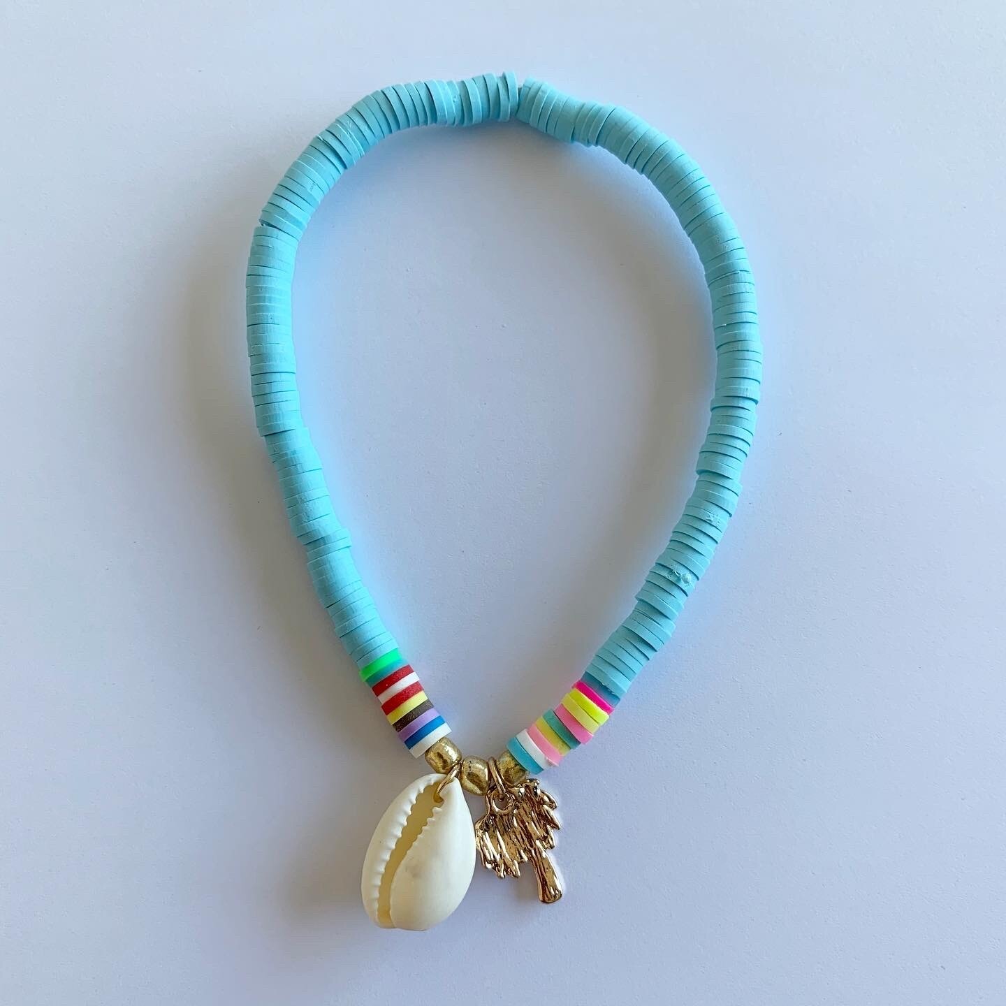 Gekleurde enkelband met schelp en palmboom licht blauw