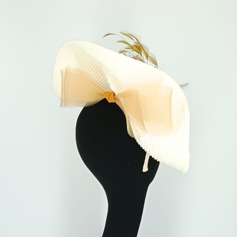 Witte fascinator op diadeem met gouden sierpluim