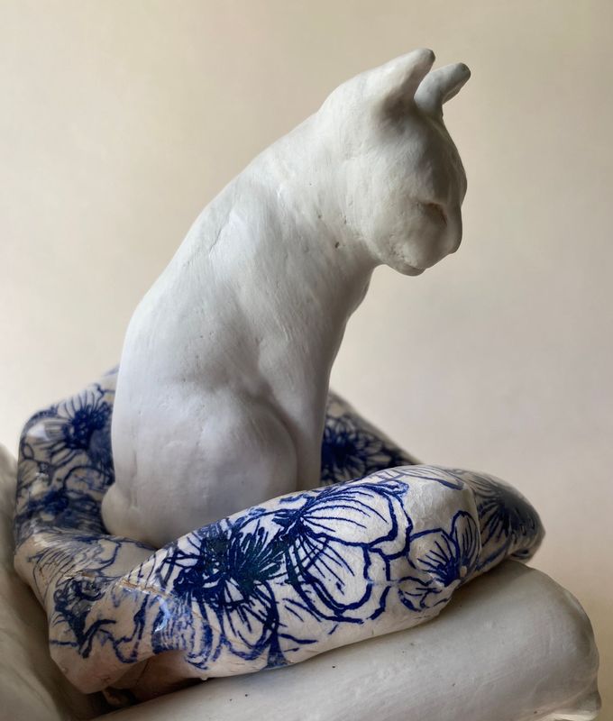 white cat on a ceramic chair