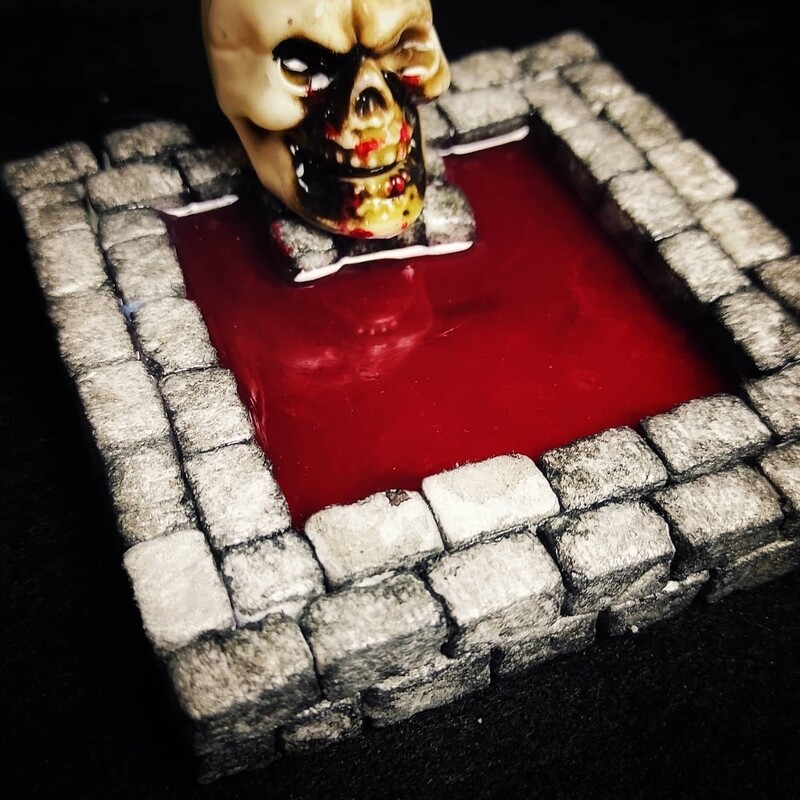 Fuente de piedra con sangre y calavera gigante sangrienta