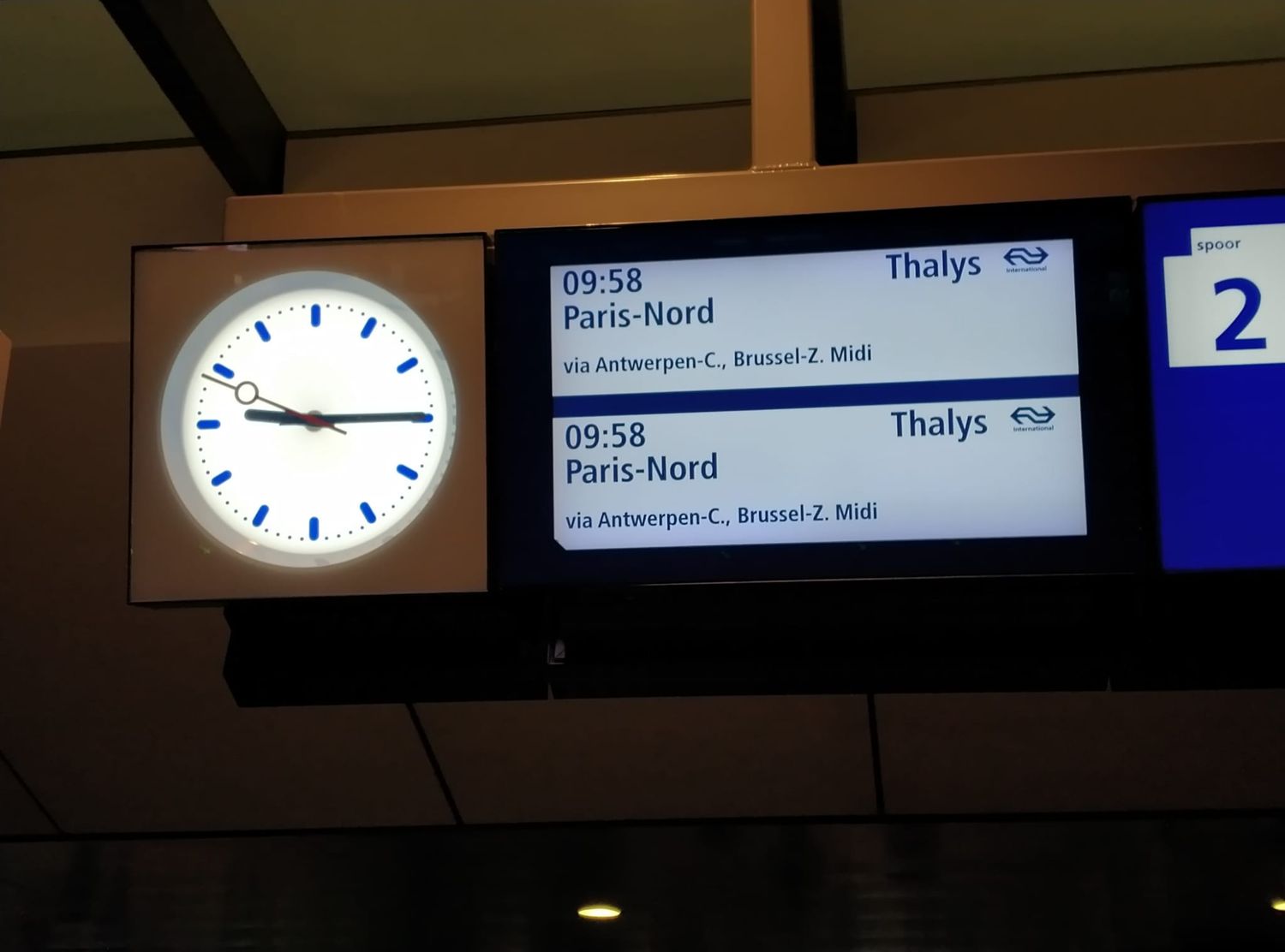 A clock whith next to the clock a display showing the time when the train to Paris-Nord is leaving