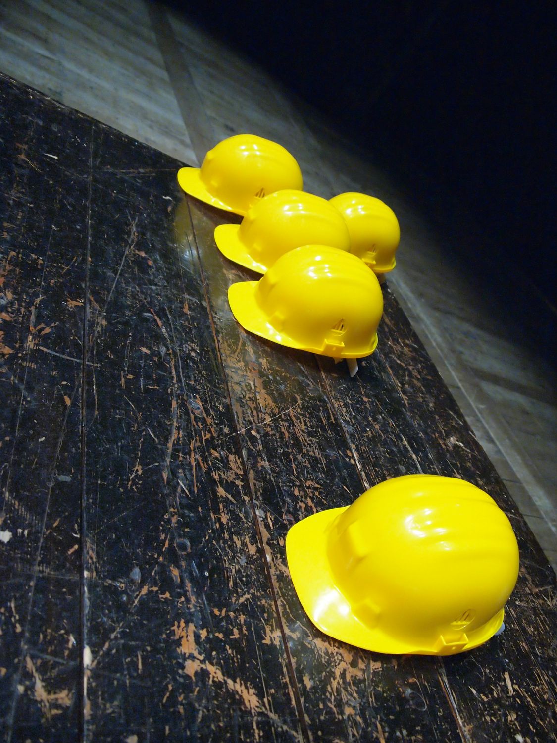 5 yellow construction helmets for safety lying on the floor
