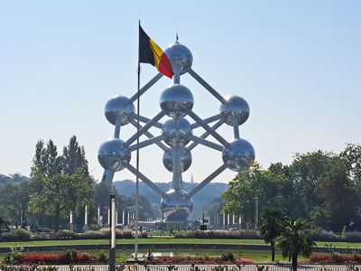 Atomium in Brussels with a Belgian flag in front, view from the Brussels Expo