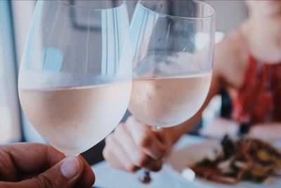 2 glasses with rose wines held for a toast