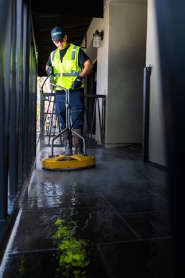 Man cleaning a floor of a building using a cleaning machine