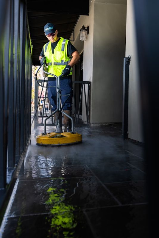Man cleaning a floor of a building using a cleaning machine