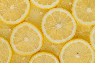 cut lemon slices against a yellow background