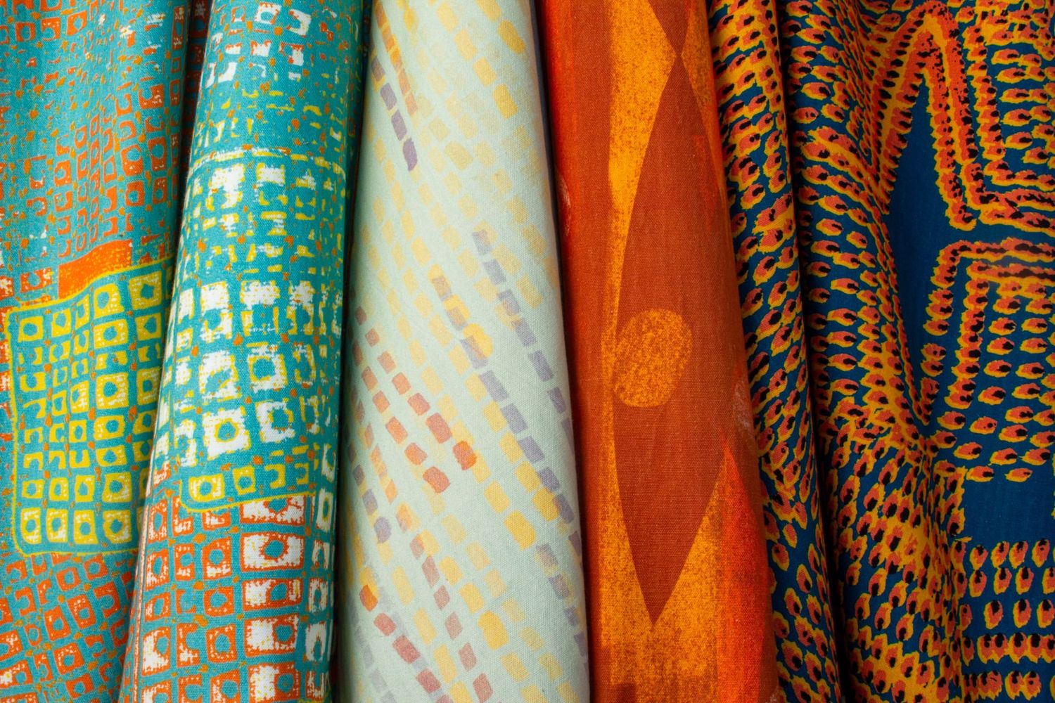 Ampli collection Flame colorway group showing Swan, Quiver, Pilot and Iris patterns in orange tones