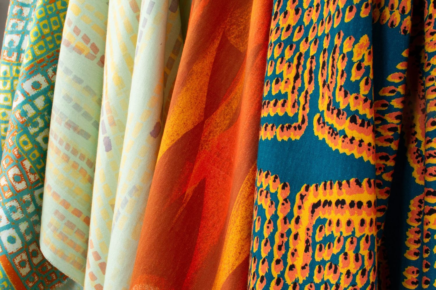 Ampli collection Flame colorway group showing Swan, Quiver, Pilot and Iris patterns in orange tones